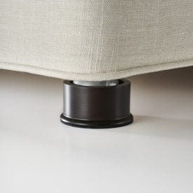 Close-up of a black furniture leg on a beige sofa.