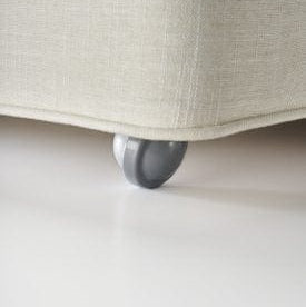 Close-up of a gray fabric ottoman with a single wheel on a light gray background