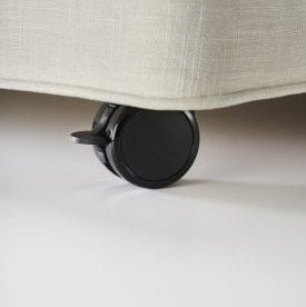Close-up of a black wheel on a beige fabric surface